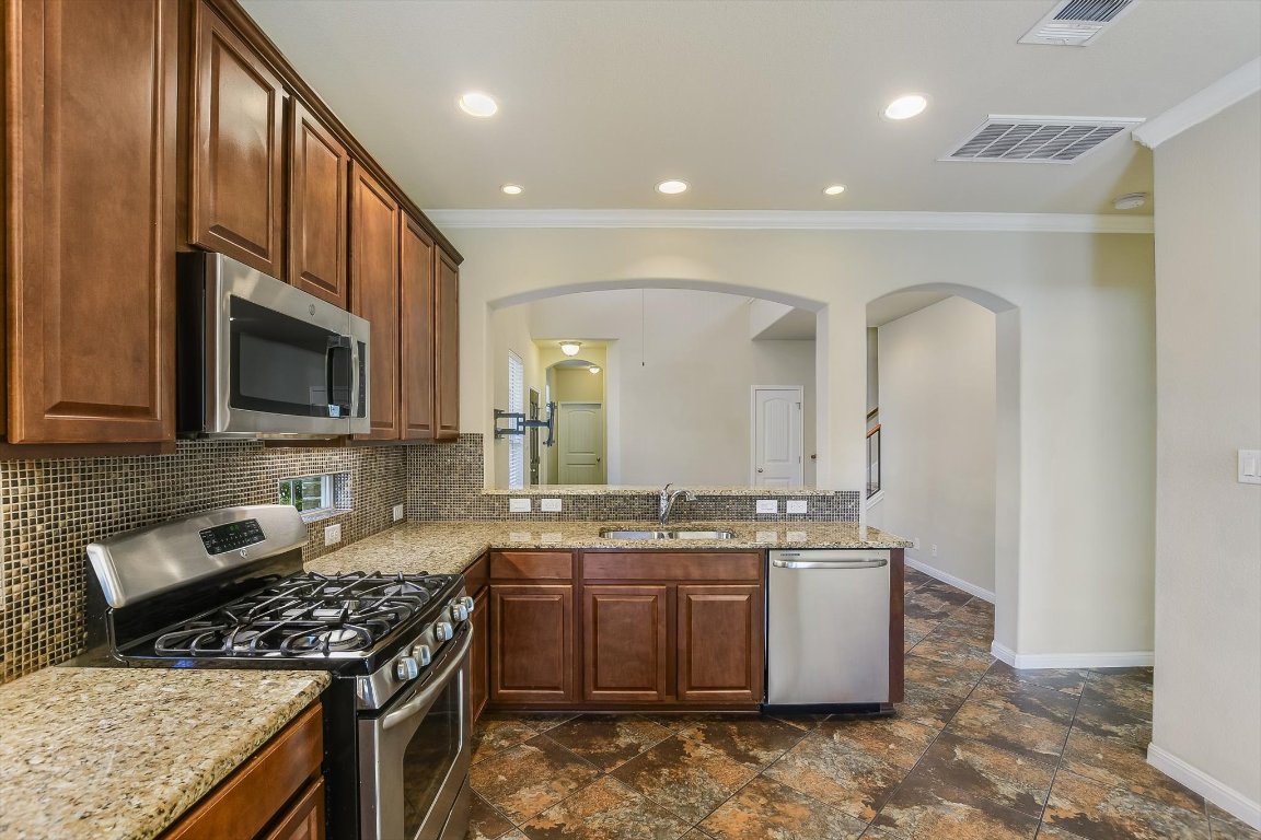 14001 Avery Ranch Boulevard, Unit 2104 Austin, TX 78717 - Photo 5 of 20 a kitchen with stainless steel appliances granite countertop a stove a sink and a microwave
