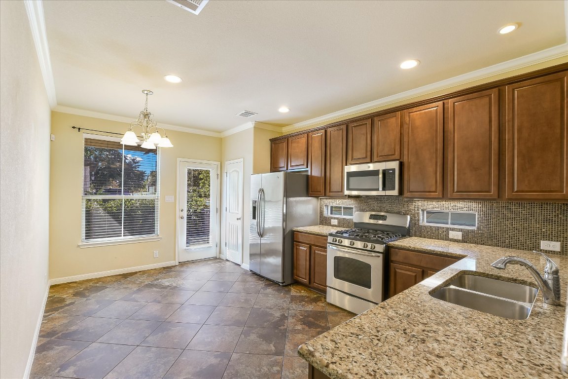 14001 Avery Ranch Boulevard, Unit 2104 Austin, TX 78717 - Photo 7 of 21 a kitchen with stainless steel appliances granite countertop a sink stove and refrigerator