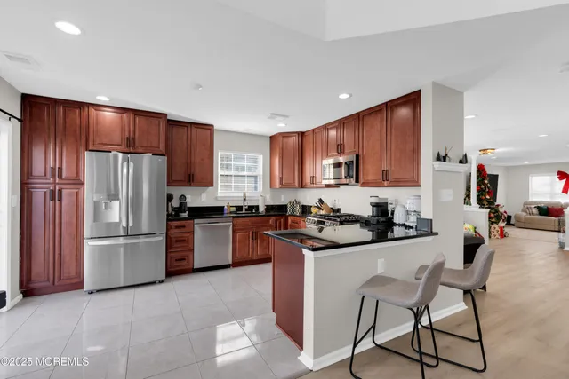 a kitchen with stainless steel appliances granite countertop a refrigerator stove a sink dishwasher and microwave