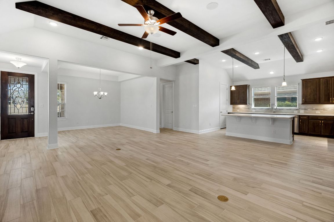 5152 Cornetto Bluffs Round Rock, TX 78665 - Photo 11 of 36 a view of an empty room with wooden floor and a kitchen