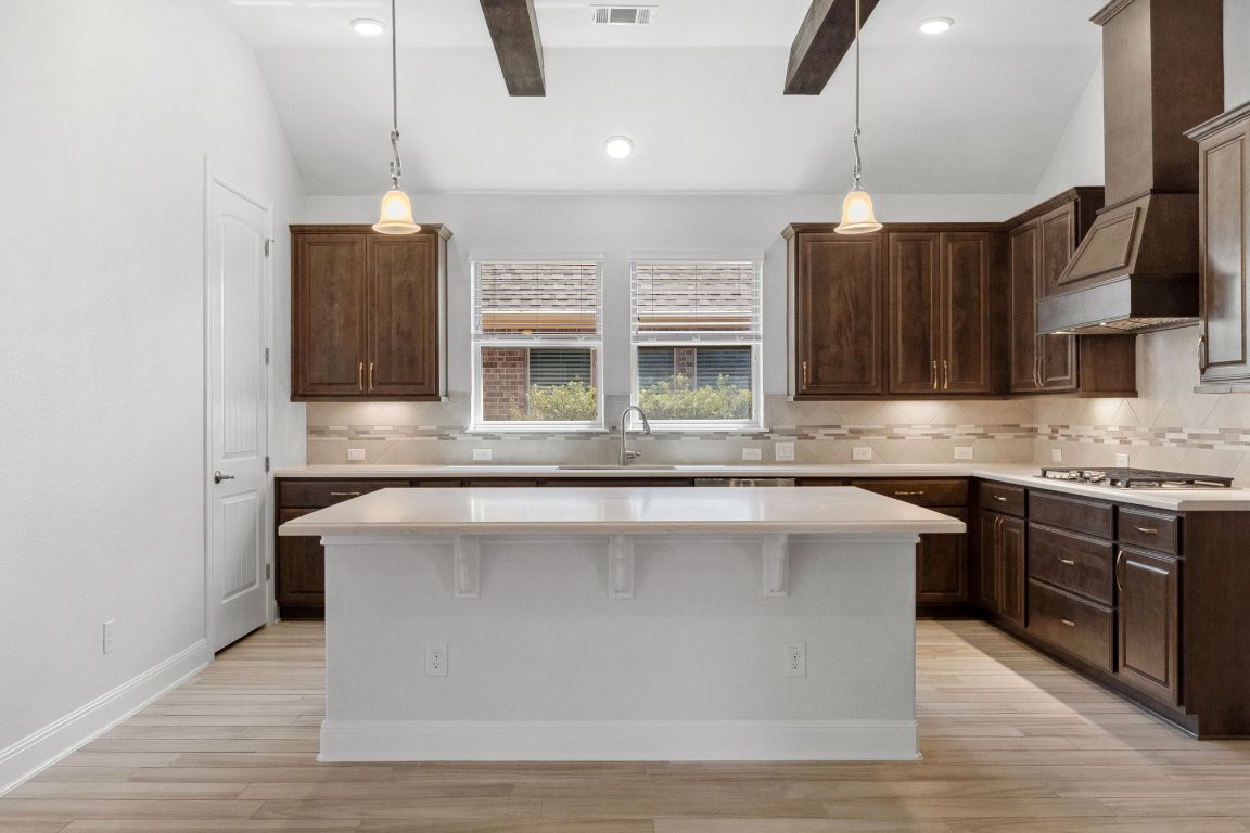 5152 Cornetto Bluffs Round Rock, TX 78665 - Photo 15 of 36 a kitchen with stainless steel appliances granite countertop a sink a stove and a wooden floors