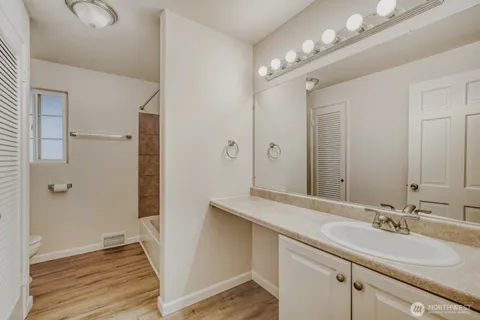 a bathroom with a tub a sink and a window