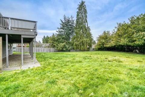 a view of a backyard with table and chairs under an umbrella