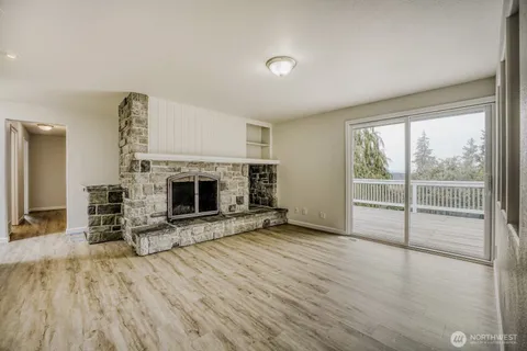 a view of empty room with a fireplace and window