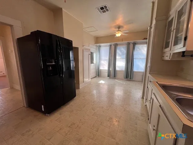 a view of gallery with windows and refrigerator