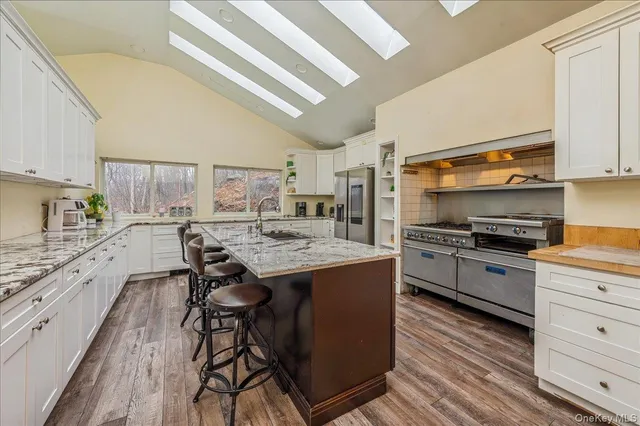 a kitchen with granite countertop a sink appliances counter top space and cabinets