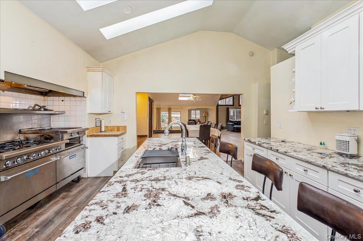 584 Milltown Road Brewster, NY 10509 - Photo 14 of 37 a large kitchen with stainless steel appliances stove a sink dishwasher and cabinets with wooden floor