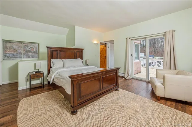 a bedroom with a large bed couch and windows