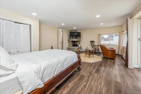a spacious bedroom with a bed and wooden floor