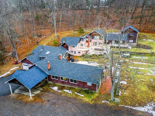 an aerial view of a house with swimming pool and large trees