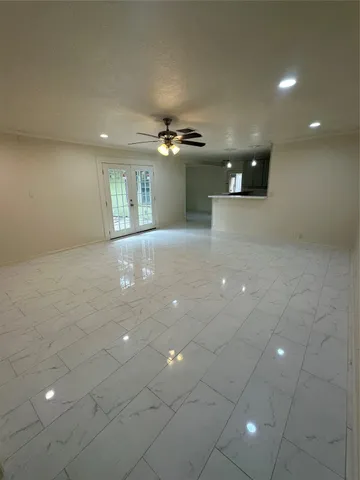 a view of a hallway with a ceiling fan and window