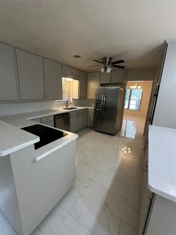 a kitchen with granite countertop a refrigerator and a stove