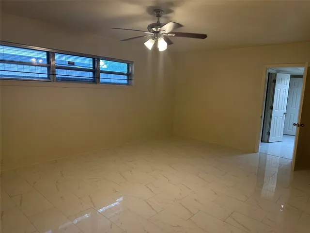 a view of a livingroom with a ceiling fan and window