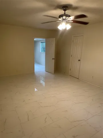 en empty room with windows and fan