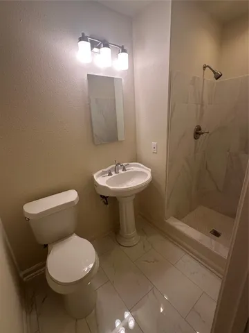 a bathroom with a toilet sink and shower