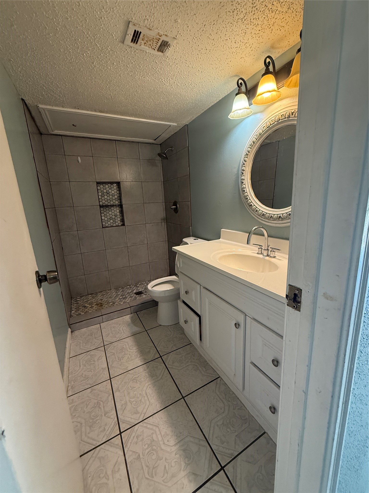 7402 Alabonson Road, Unit 407 Houston, TX 77088 - Photo 7 of 14 a bathroom with a toilet sink and mirror