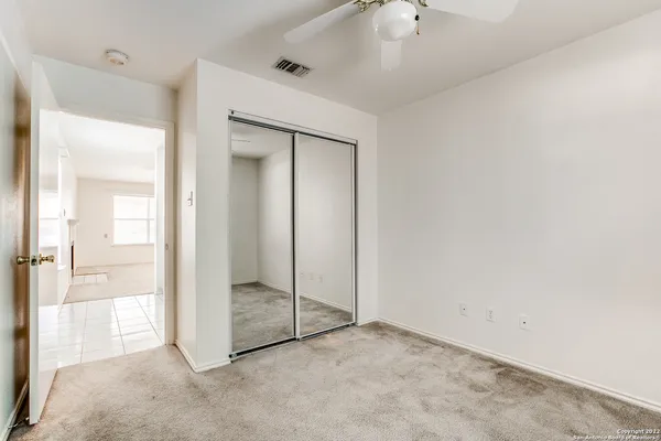 a view of an empty room and a ceiling fan