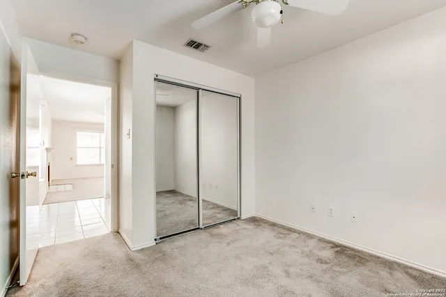 a view of an empty room and a ceiling fan