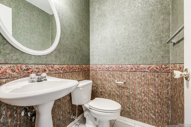 a bathroom with a sink a toilet and a mirror