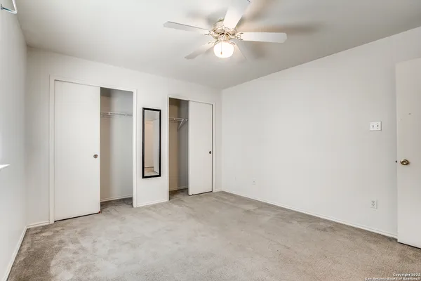 an empty room with a ceiling fan and a window