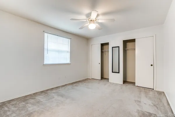 a view of an empty room with a ceiling fan