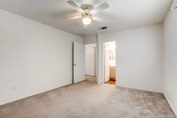 an empty room with a ceiling fan and a window