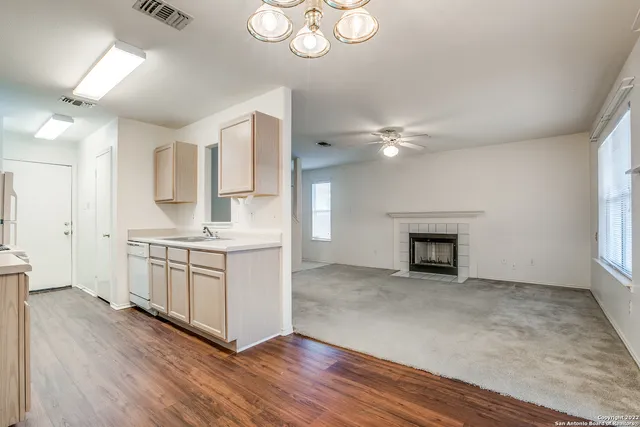 a kitchen with stainless steel appliances granite countertop a sink cabinets and wooden floor
