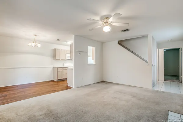 a view of a kitchen with a sink and chandelier fan