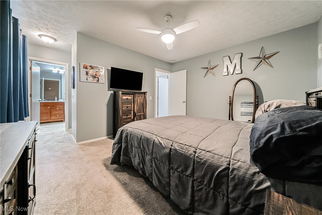 10794 Waterfall Road Strongsville, OH 44149 - Photo 18 of 37 Bedroom featuring light colored carpet, a textured ceiling, ensuite bath, and ceiling fan