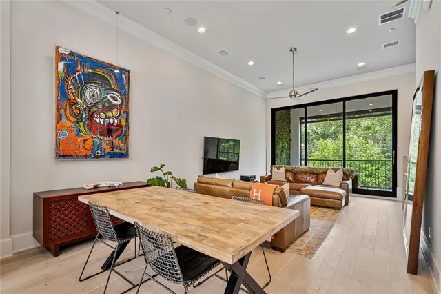 a living room with furniture two large window and a flat screen tv
