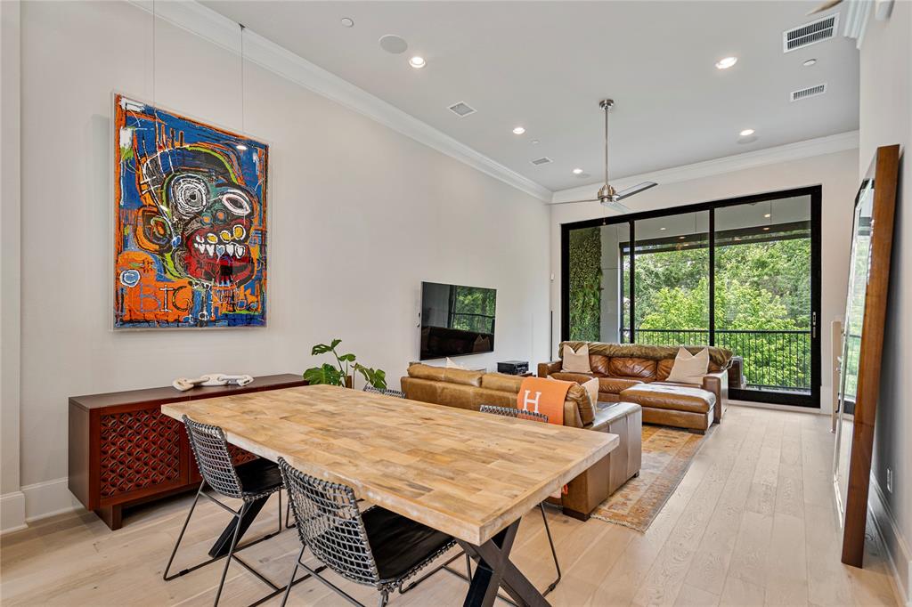 a living room with furniture two large window and a flat screen tv