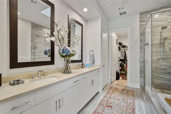 a bathroom with a double vanity sink mirror and shower
