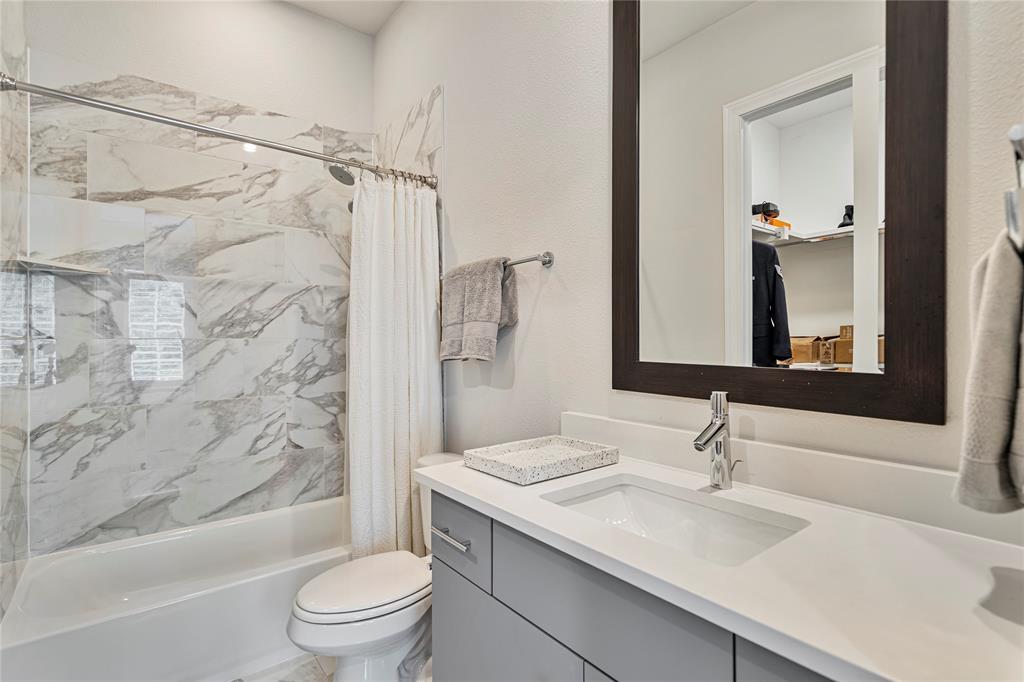 2157 Wenge Lane Dallas, TX 75219 - Photo 17 of 26 a bathroom with a granite countertop sink toilet and shower