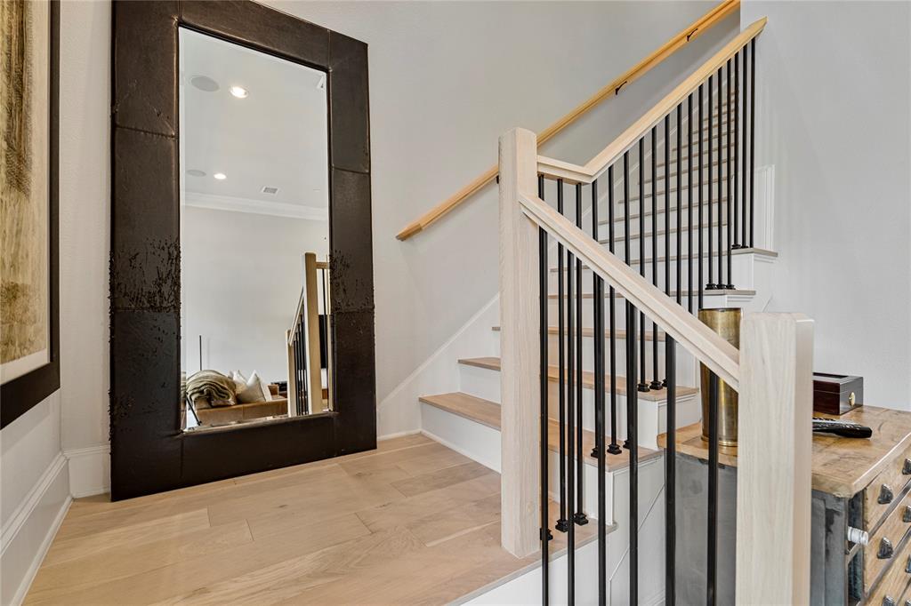 2157 Wenge Lane Dallas, TX 75219 - Photo 25 of 26 a view of a hallway with wooden floor and stairs