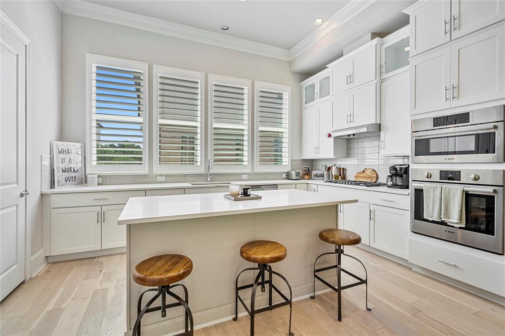 2157 Wenge Lane Dallas, TX 75219 - Photo 26 of 26 a kitchen with stainless steel appliances a stove a sink and white cabinets with wooden floor