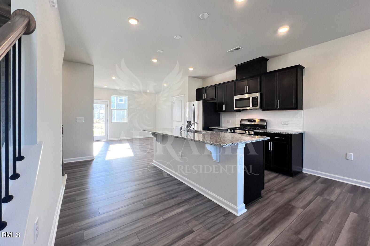 181 Ivy Vine Way Raleigh, NC 27610 - Photo 4 of 22 a kitchen with stainless steel appliances a microwave a stove a sink a refrigerator and a microwave