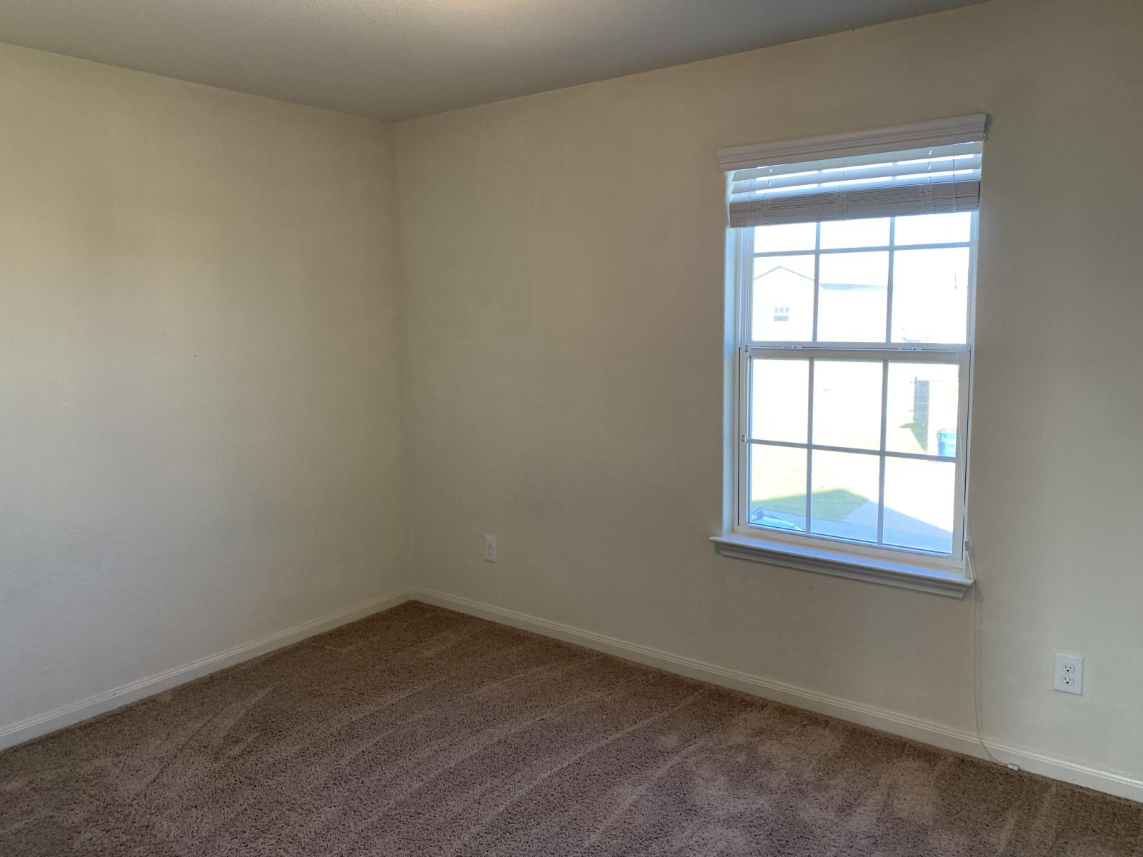 217 Denson Lane Jarrell, TX 76537 - Photo 11 of 26 Room featuring neutral wall tones, textured carpeting, and a double-hung window with blinds