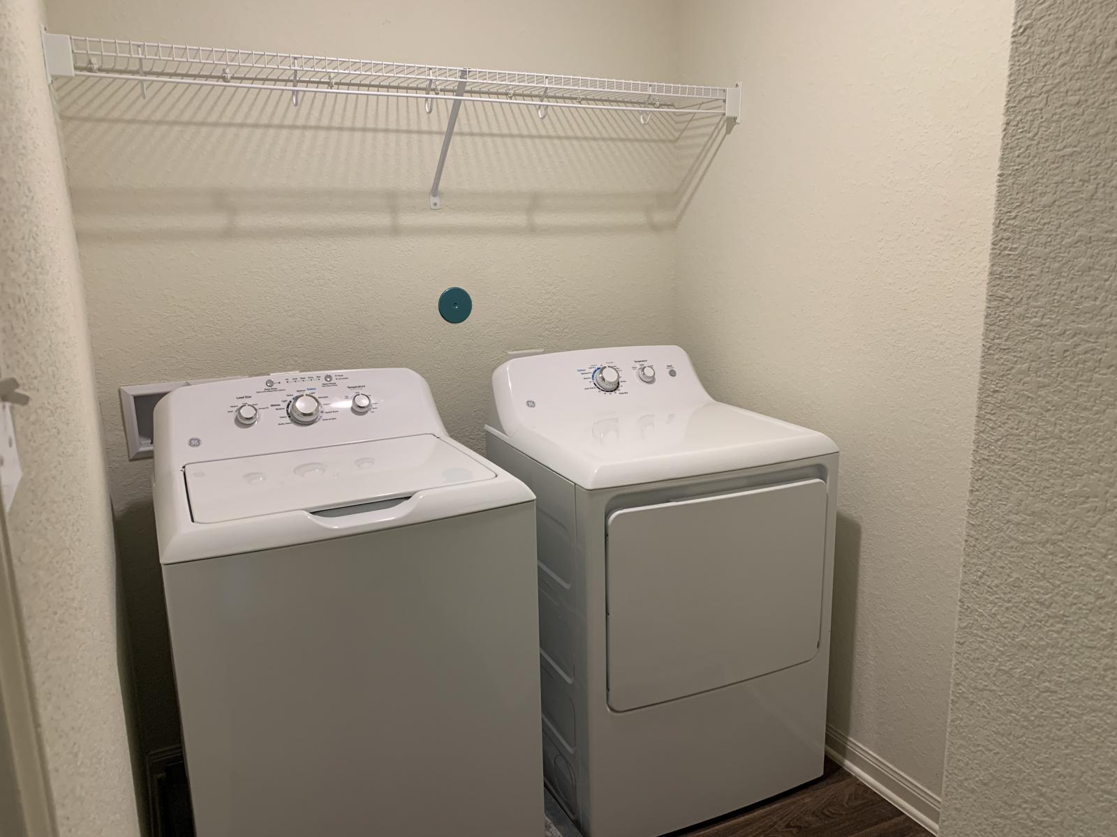 217 Denson Lane Jarrell, TX 76537 - Photo 12 of 26 Dedicated laundry area featuring a washer and dryer, an overhead wire shelf, and wood-finish flooring