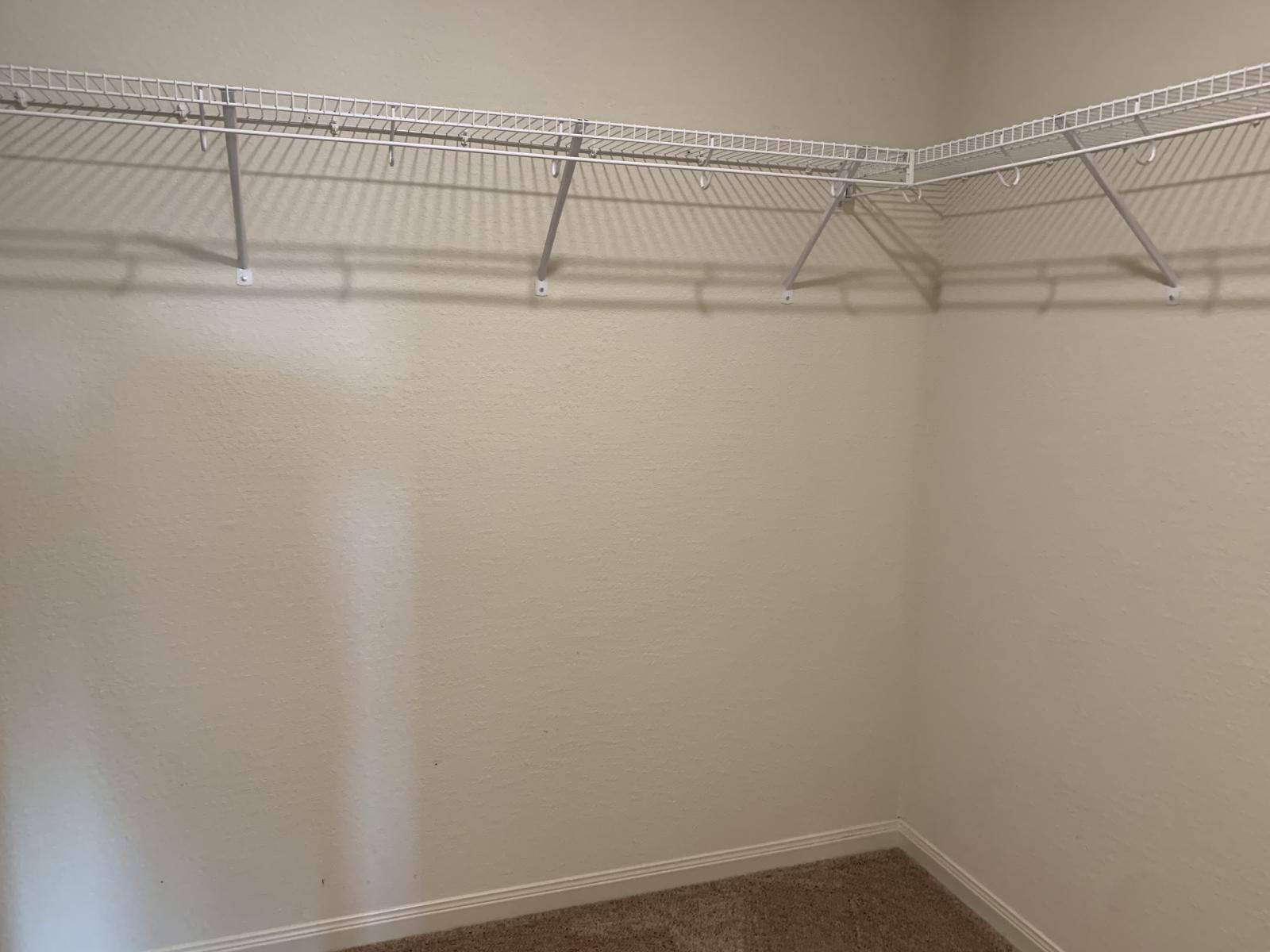 217 Denson Lane Jarrell, TX 76537 - Photo 18 of 26 Walk-in closet with white wire shelving system and neutral carpeting