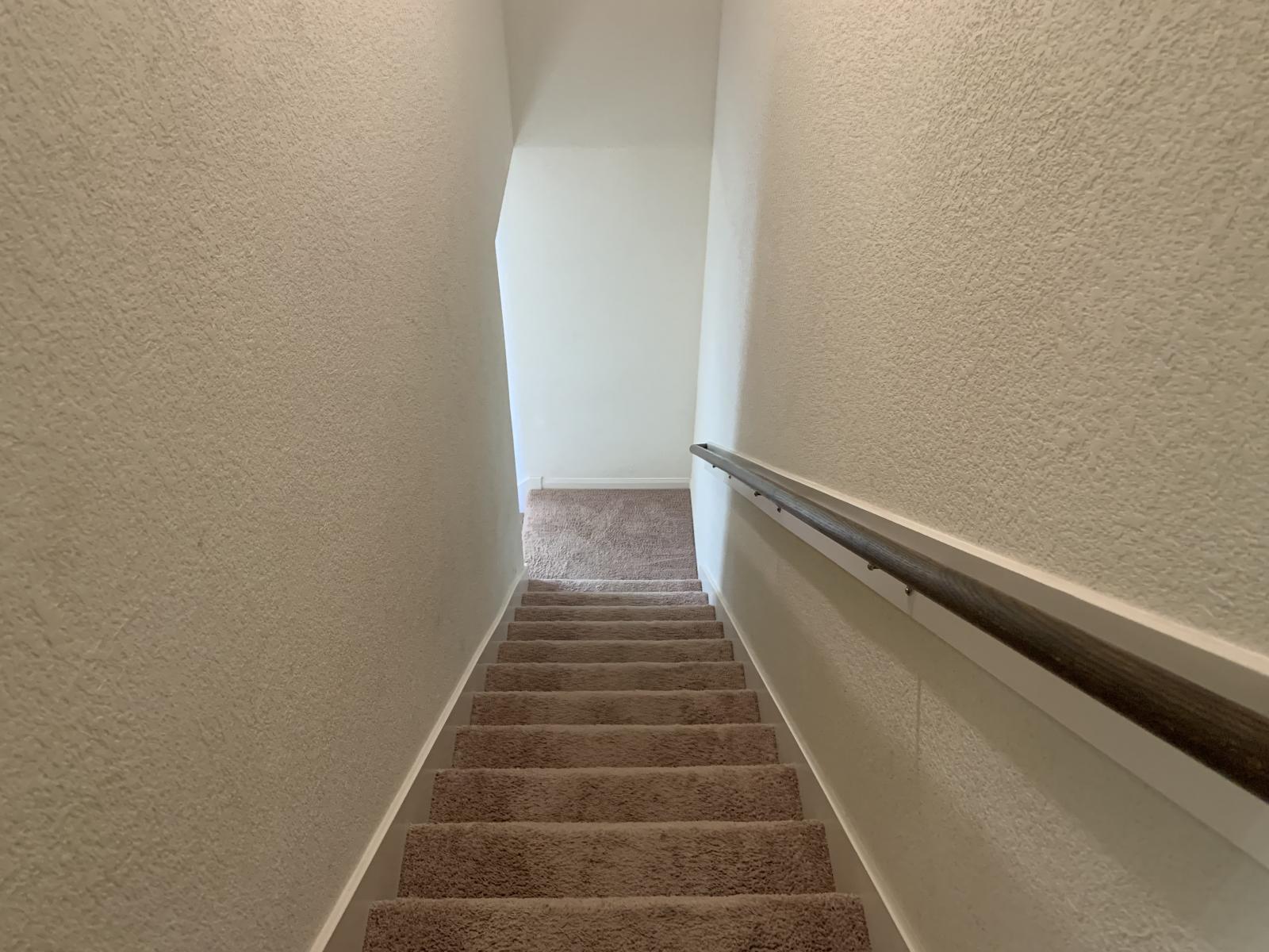 217 Denson Lane Jarrell, TX 76537 - Photo 20 of 26 Carpeted staircase with textured walls and a dark wood handrail