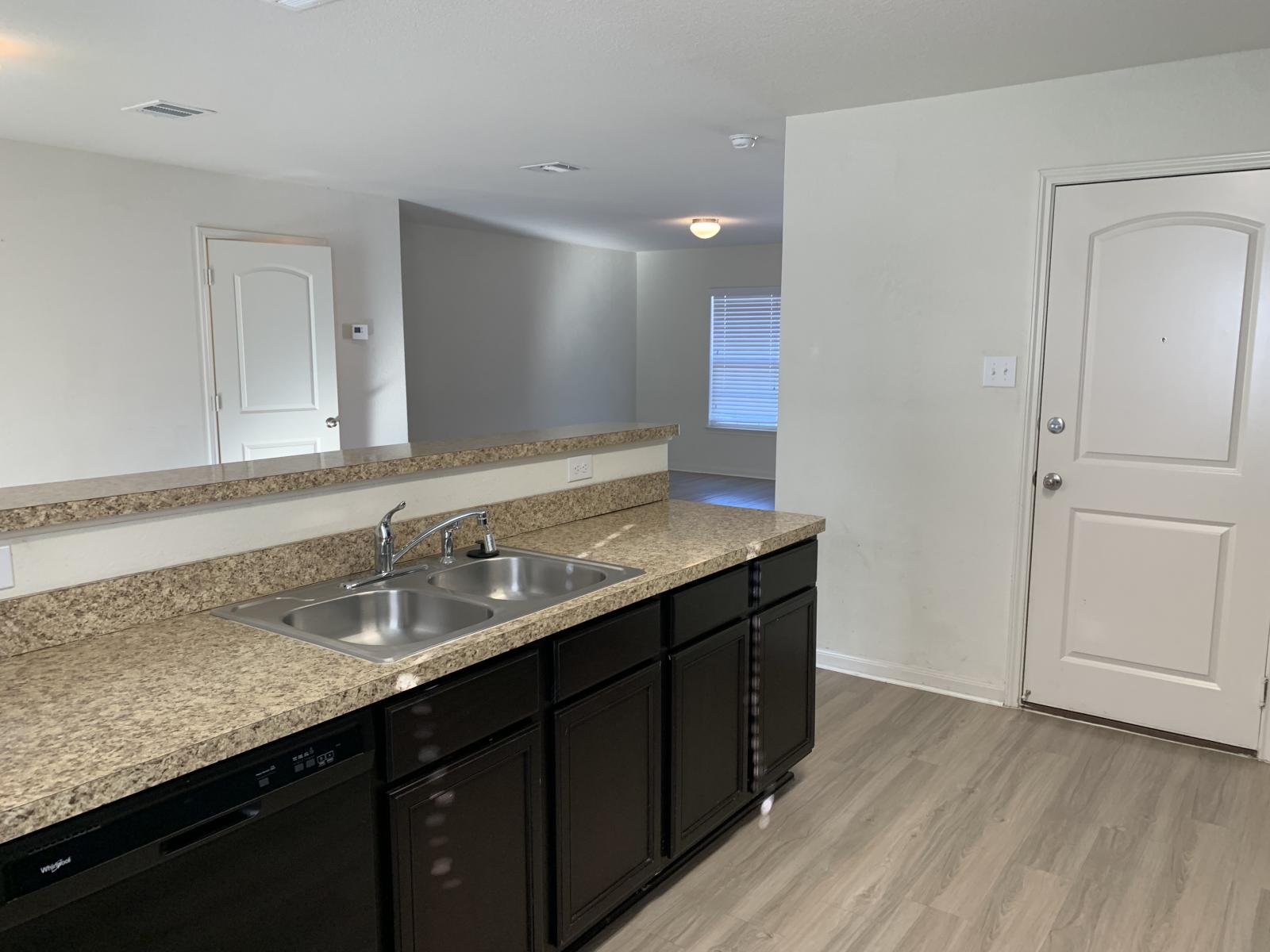 217 Denson Lane Jarrell, TX 76537 - Photo 4 of 26 Kitchen featuring a double stainless steel sink, speckled countertops, dark wood cabinetry, and a black dishwasher