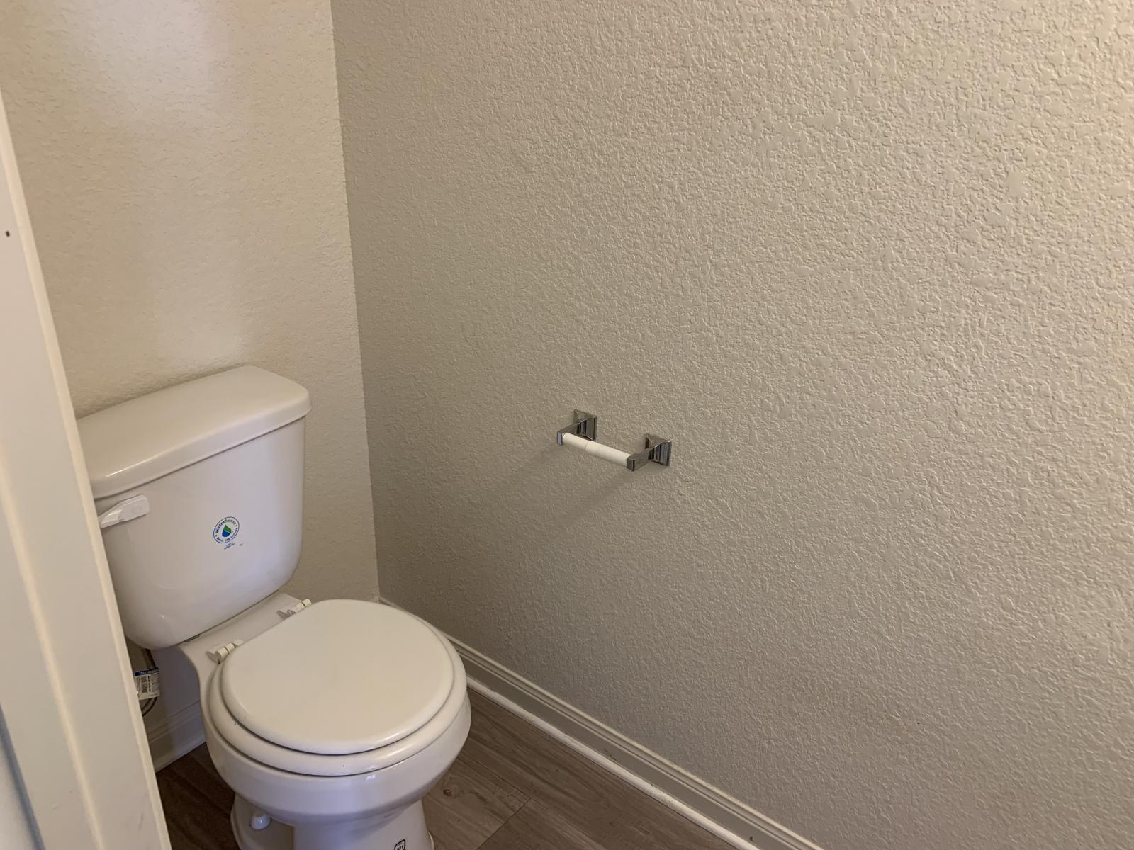 217 Denson Lane Jarrell, TX 76537 - Photo 9 of 26 Compact water closet featuring a white toilet, neutral wall texture, wood-finish flooring, and a chrome toilet paper holder