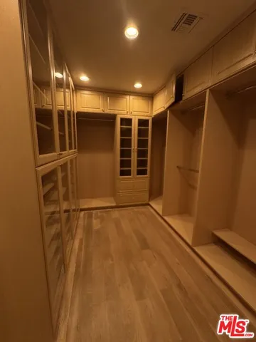 a view of an empty room with wooden floor and garage