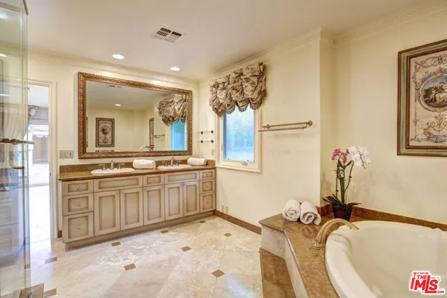 a bathroom with a tub sink and mirror