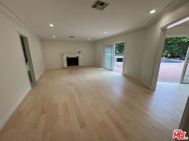 a view of empty room with wooden floor and window