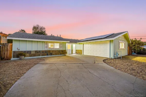 a view of a house with backyard and a garage