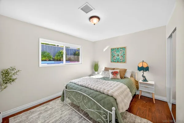 a bedroom with a bed and wooden floor