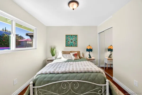 a bedroom with a bed and a wooden floor