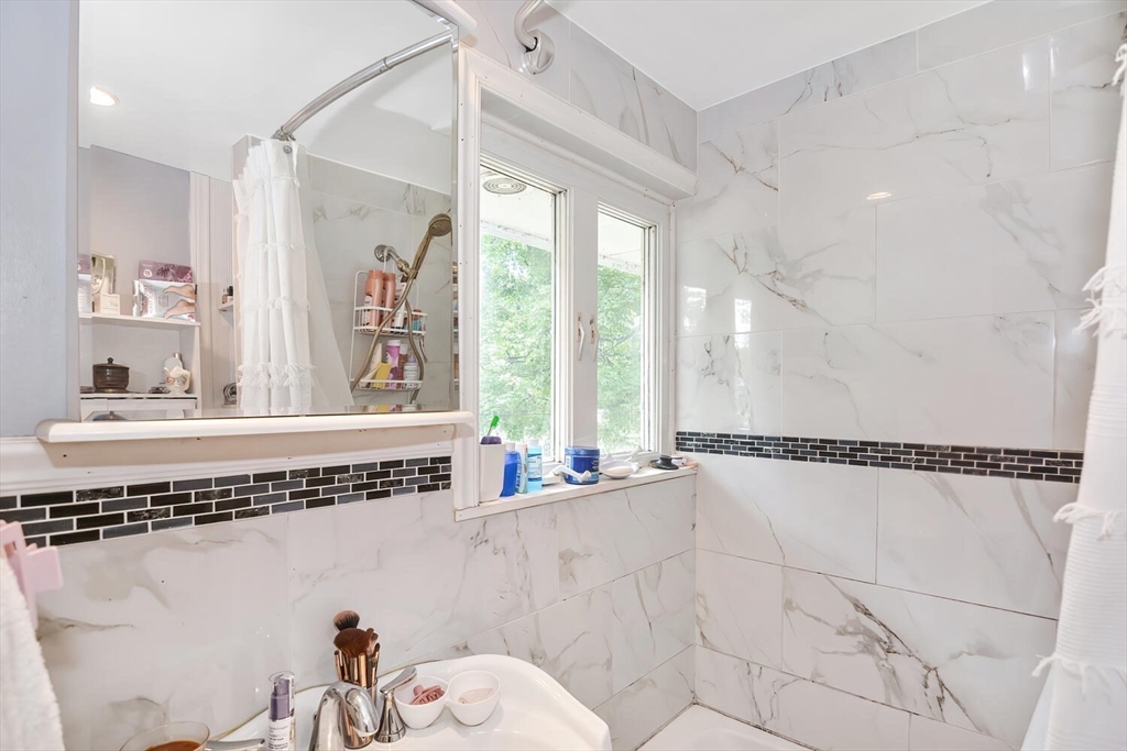 9 Flagg Drive Framingham, MA 01702 - Photo 11 of 22 a view of a bathroom with a tub a sink and a window