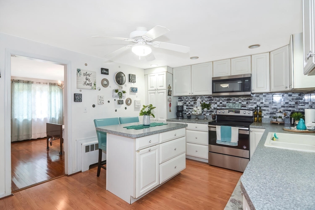 9 Flagg Drive Framingham, MA 01702 - Photo 4 of 22 a kitchen with stainless steel appliances granite countertop a stove cabinets and wooden floor